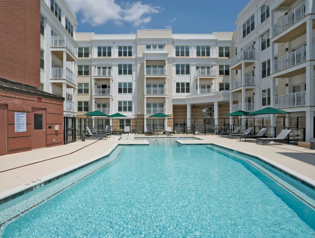 pool with deck seating surrounded by apartment balconies