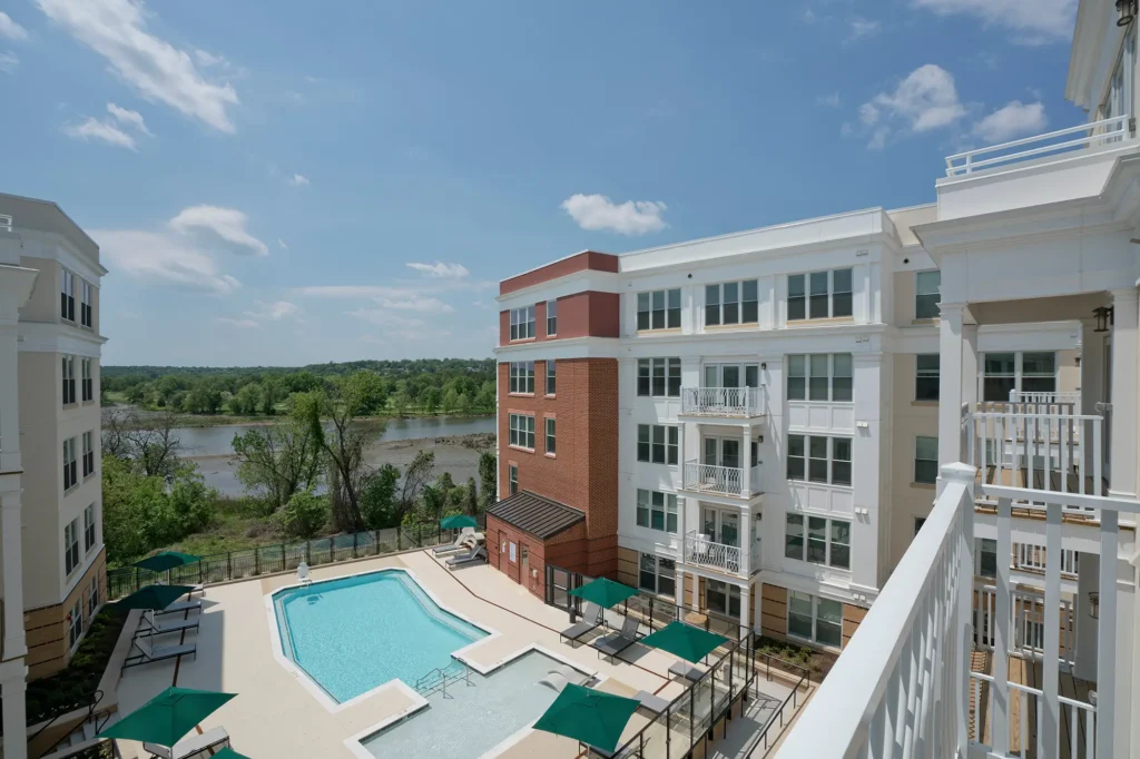 View from apartment balcony overlooking pool and trees