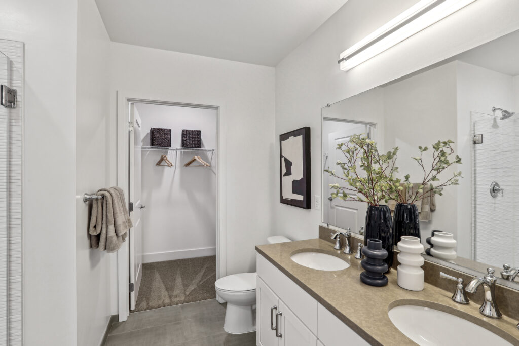 Bathroom with double vanity and walk in closet